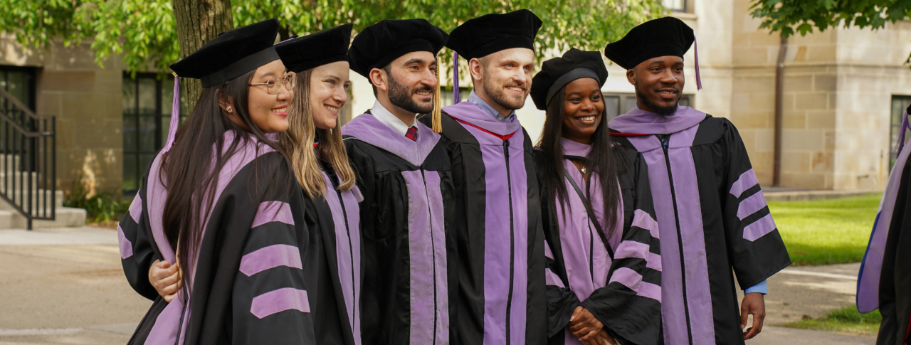 Group of dental graduates sharing a hug.